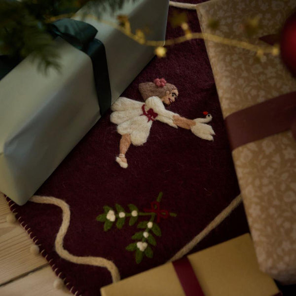 Odette Heirloom Tree Rug displayed under a Christmas tree, adding a cozy and festive touch to holiday decor.