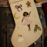 Close-up of embroidered ballerina on cream white holiday stocking, highlighting meticulous craftsmanship and punch needle details.