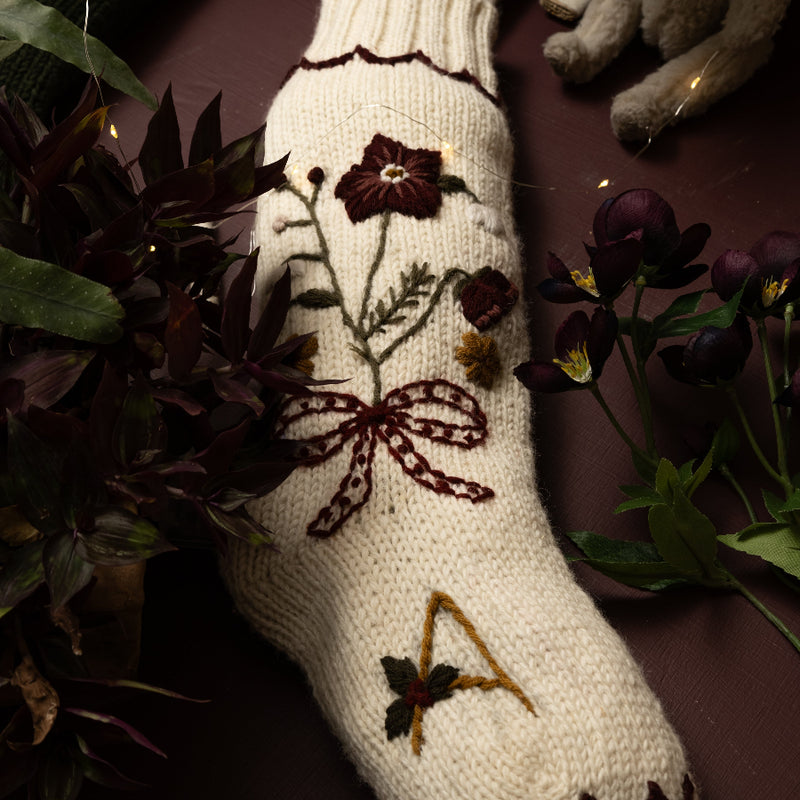 White sock with floral embroidery on a dark background