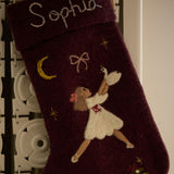 Dark grape holiday stocking with personalized Odette and a vertical name embroidery, hanging from a stocking holder, emphasizing its custom design and handcrafted quality.