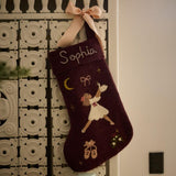 Personalized dark grape holiday stocking with embroidered Odette, hanging on a mantel. Includes custom name in cursive, showcasing elegant handcrafting and festive details.