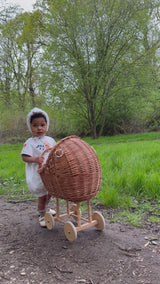 Child pushing a wooden stroller wearing Midsummer Bonnet and Romper