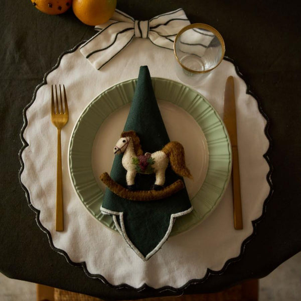 Cream White Bow placemats arranged on a dining table, showcasing their festive design and sophisticated appeal in a holiday setting.