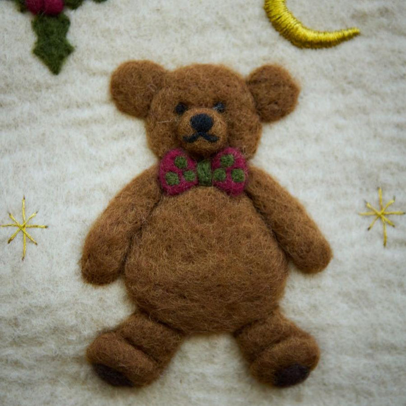 Close-up of the embroidered teddy bear on the cream white holiday stocking, showcasing intricate handcrafting and detailed punch needle work.