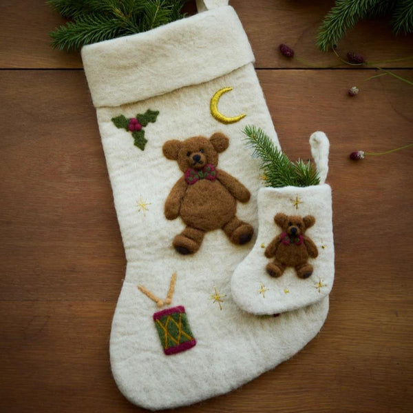 Cream white holiday stocking with embroidered teddy bear displayed in a festive setting, adding a touch of whimsy and charm to holiday decorations.