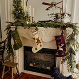 felted christmas stocking hanging on a fireplace