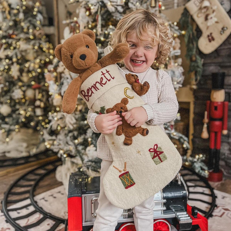 child holding personalized teddy stocking for christmas