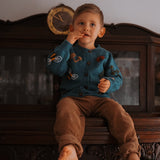 little boy wearing petroleum knitted and embroidered bugs life cardigan