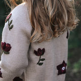 a girl wearing knitted and embroidered hellebores cardigan