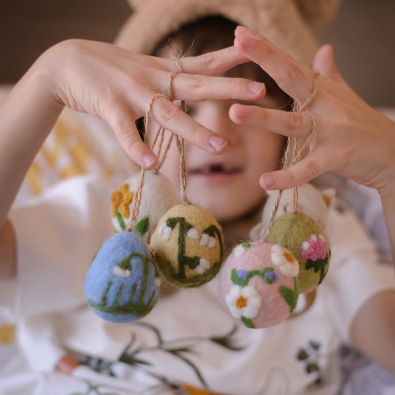 a boy holding egg ornaments 