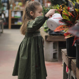 girl in green dress in flower garden