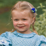 Young girl in a blue dress with floral details outdoors