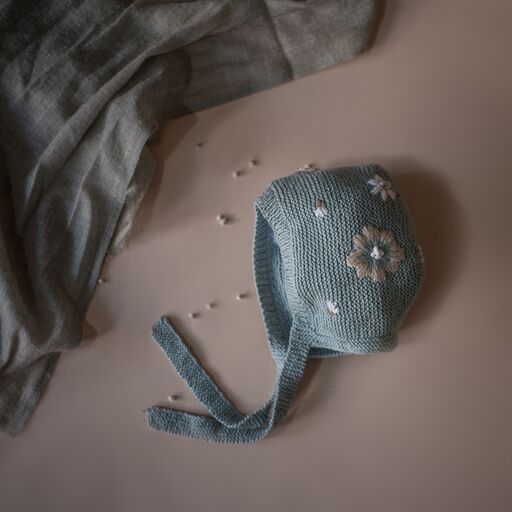 This gorgeous bonnet is knitted by hand in our signature vegan cotton, and afterwards we have embroidered this fantastic flower embroidery by hand.