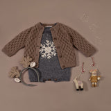 flat lay picture of hand knitted snowflake romper along withh smock cardigan nutty brown