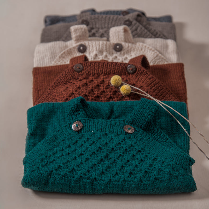 flat lay picture of hand knitted smock jumpsuit in different colours