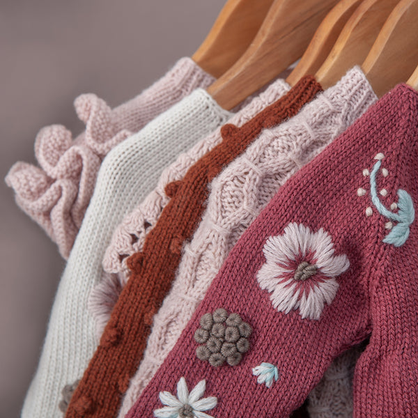 Detail picture of different hand knitted sweater along with flora sweater in front