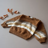 flat lay picture of hand knitted sweater with rainbow stripes in the middle both in back and front part