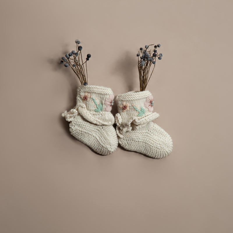 hand knitted and embroidered baby footies in white