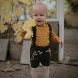yellow popcorn sweater and hand knitted suspender shorts in green with woodland embroidery