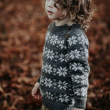 baby boy wearing hand knitted star sweater in dark grey