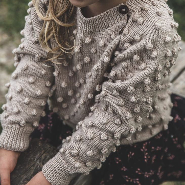 Girl wearing hand knitted sweater oats in bubble style 