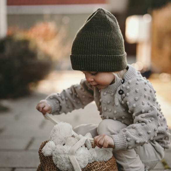 cute baby boy wearing beautifully hand knitted everyday hat in moss