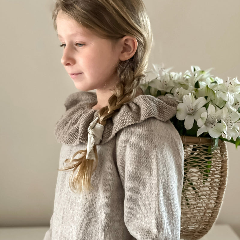 little girl in nude hand knitted sweater with taupe collar