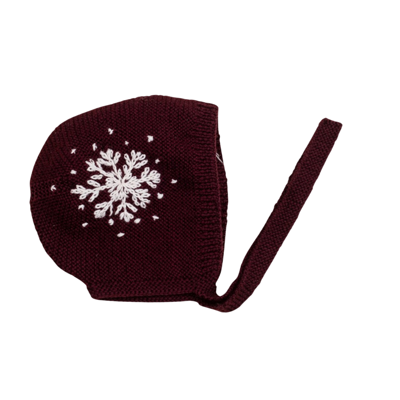 Hand-knitted snowflake bonnet in dark grape color, featuring large embroidered snowflakes on each side and tie bands under the chin.