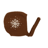 Hand-knitted caramel snowflake bonnet with large embroidered snowflakes on each side and tie bands under the chin, made from soft 100% merino wool.