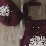 Close-up video showcasing intricate details of a dark grape hand-knitted snowflake romper and matching bonnet, highlighting embroidery, fabric texture, and adjustable features.