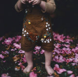 detail picture of baby wearing woodland romper caramel 