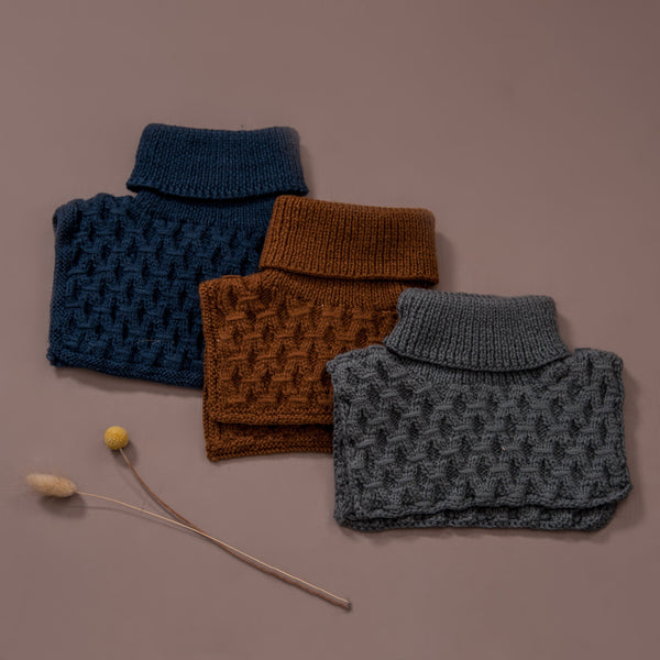 Flat lay picture of hand knitted smock neckwarmer in three different colour, navy, caramel and dark grey