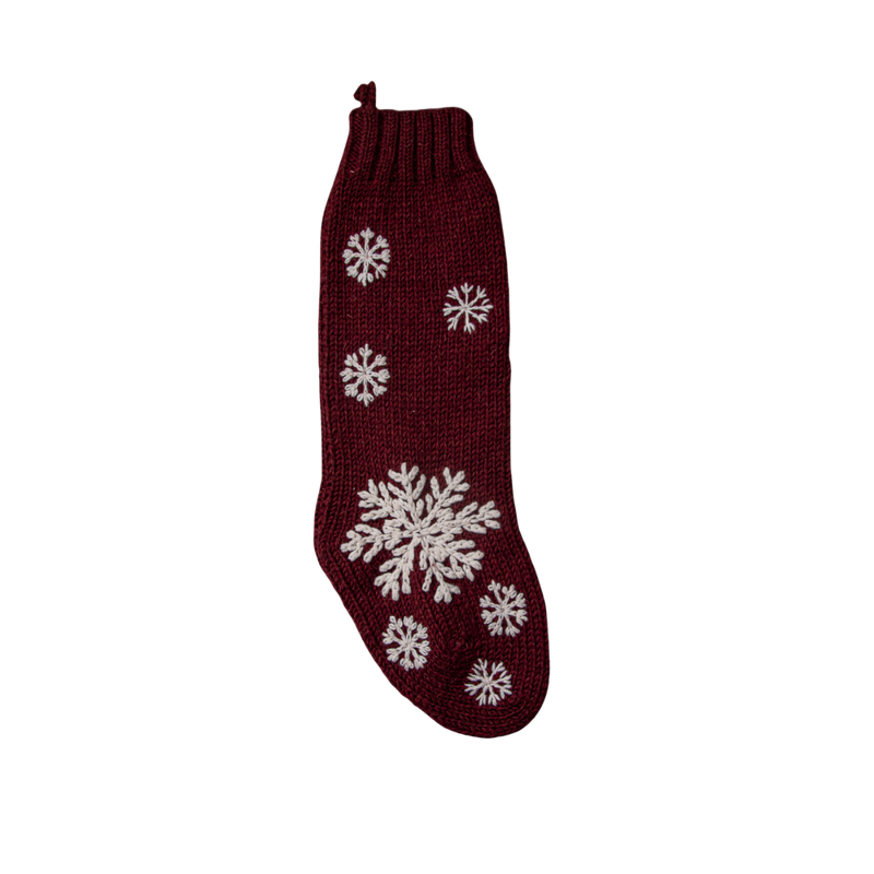 Hand-knitted Christmas stocking in Dark Grape color featuring a hand-embroidered snowflake and JOY pattern, designed to hold treasures from Santa.