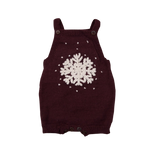 Hand-knitted dark grape romper with large front snowflake embroidery and scattered snowflakes, featuring adjustable button straps and ribbed thigh closures.