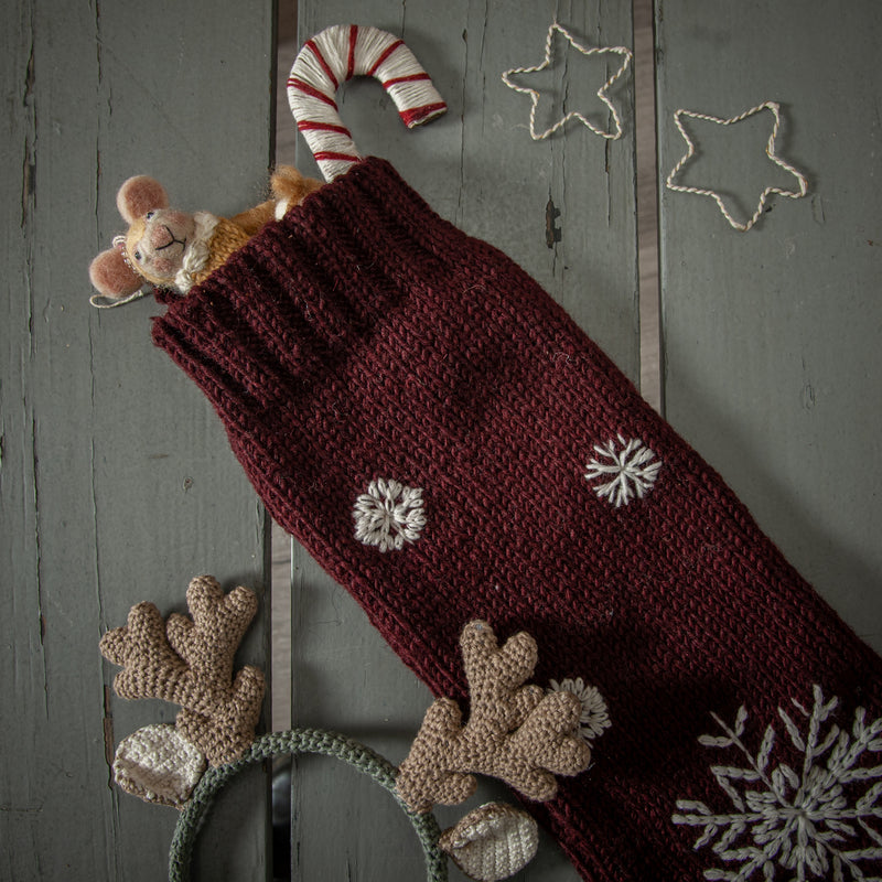 red christmas embroidered stocking filled with gifts